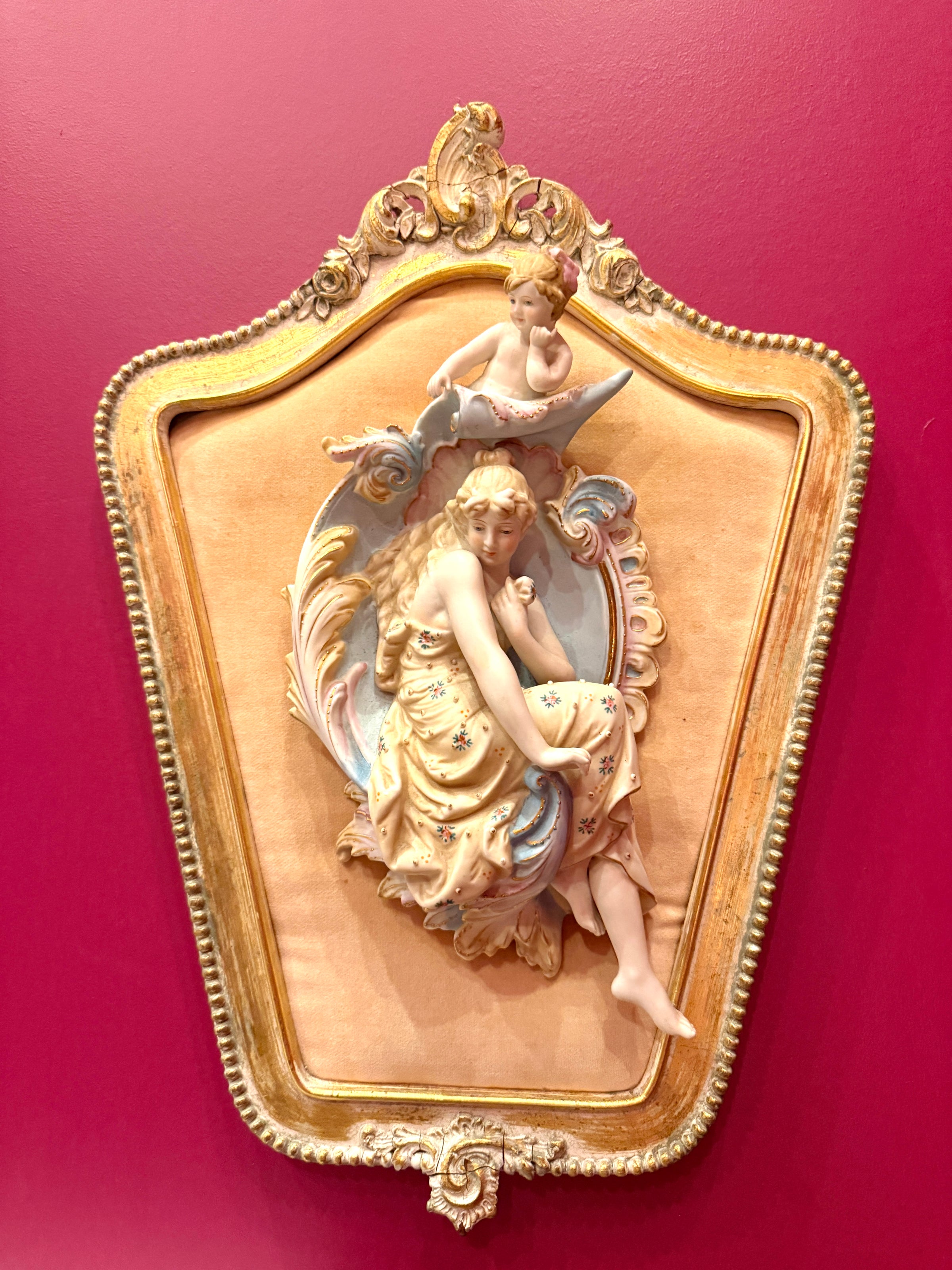 Decorative wall piece with a woman and child design on a red background