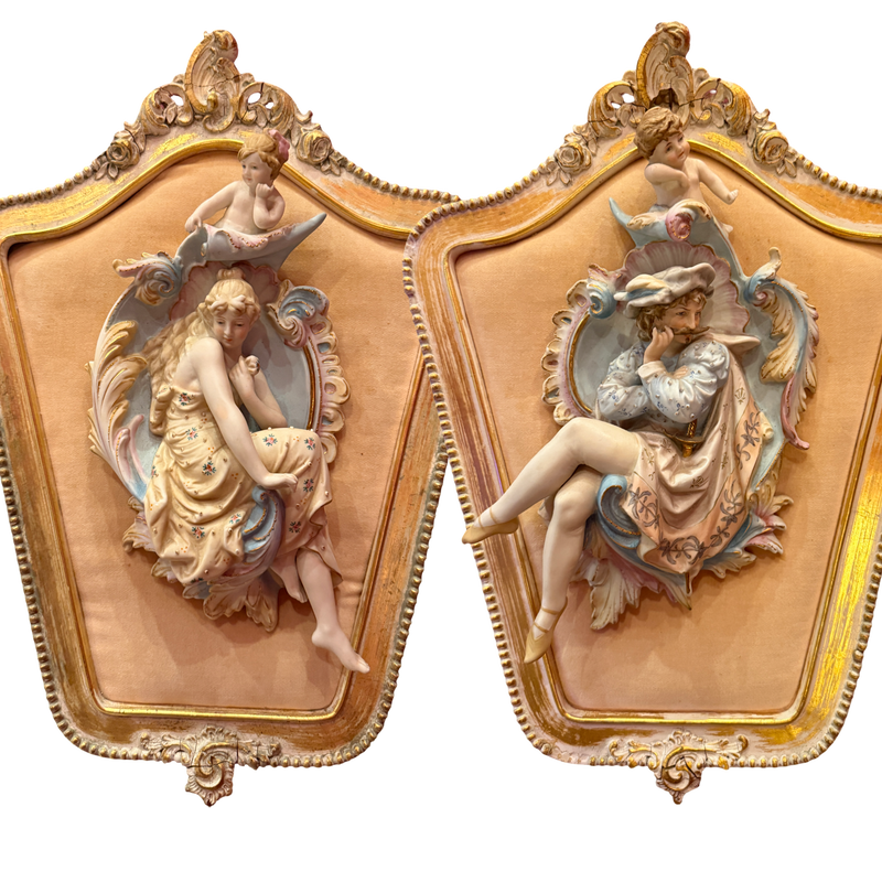Decorative wall art pieces with classical female figures and ornate gold frames.