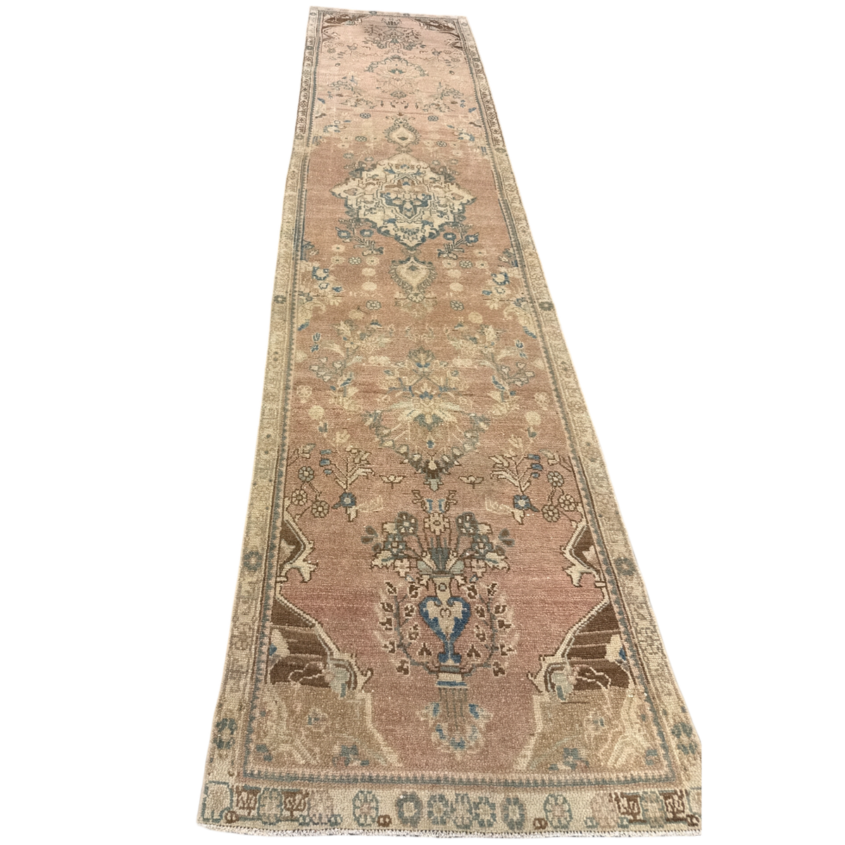 Long rectangular rug with intricate patterns on a white background