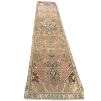 Long rectangular rug with intricate patterns on a white background