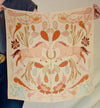 Decorative fabric with horse and floral pattern held by a person